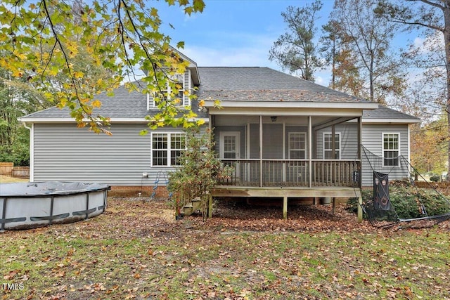 rear view of house with a covered pool and a sunroom