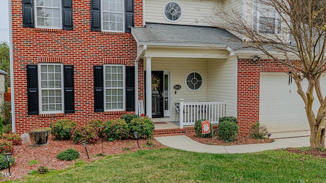 view of exterior entry with covered porch and a garage