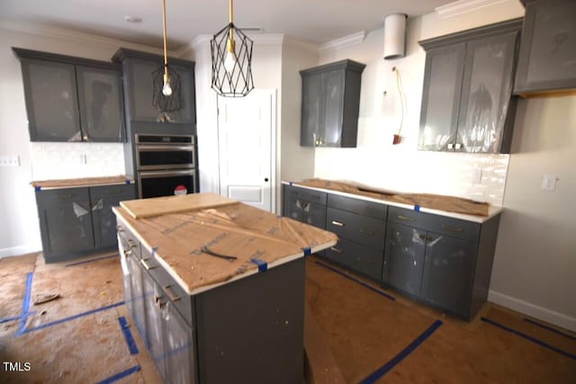 kitchen with a center island, light stone countertops, double oven, ornamental molding, and decorative light fixtures