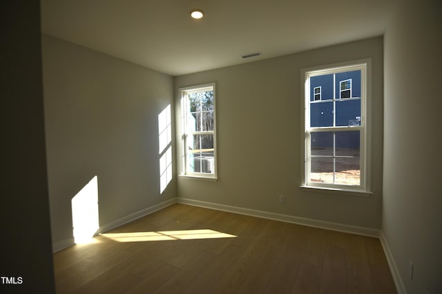 spare room featuring recessed lighting, visible vents, baseboards, and wood finished floors