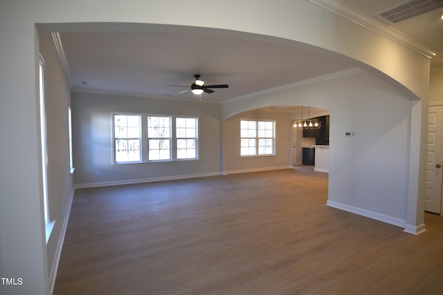 unfurnished living room featuring ornamental molding, visible vents, dark wood finished floors, and ceiling fan with notable chandelier