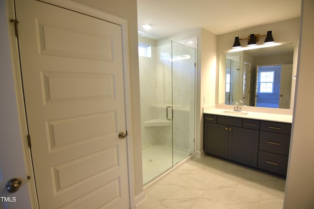 bathroom with marble finish floor, vanity, and a stall shower