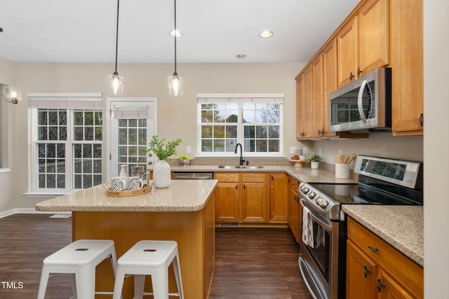 kitchen with sink, a breakfast bar, dark hardwood / wood-style flooring, and stainless steel appliances