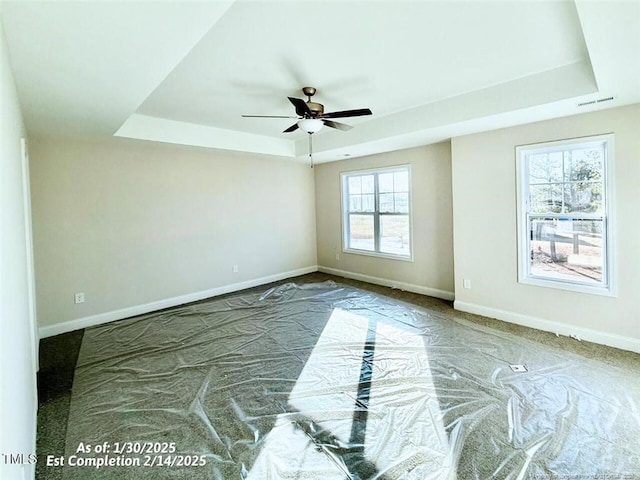 unfurnished room with a raised ceiling and ceiling fan