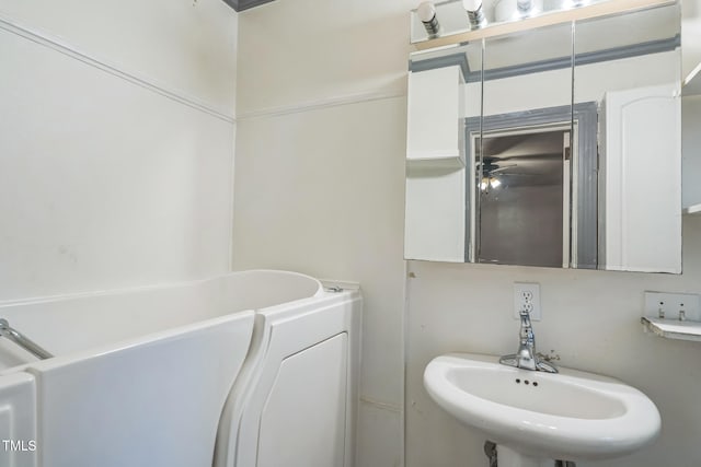 bathroom with ceiling fan, a bathing tub, and sink