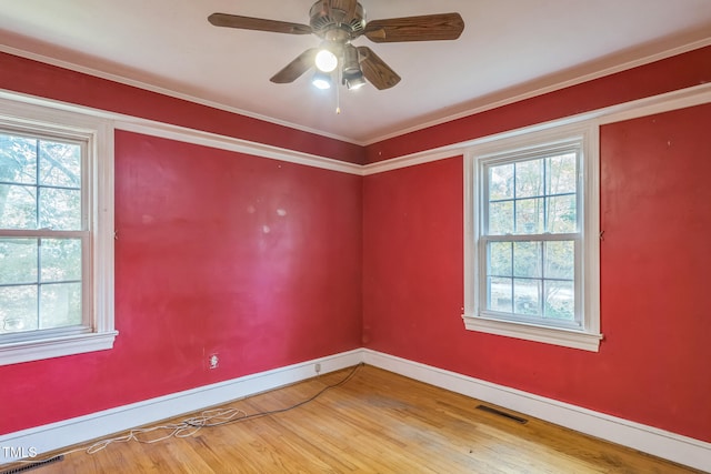 spare room with hardwood / wood-style floors, a wealth of natural light, ornamental molding, and ceiling fan