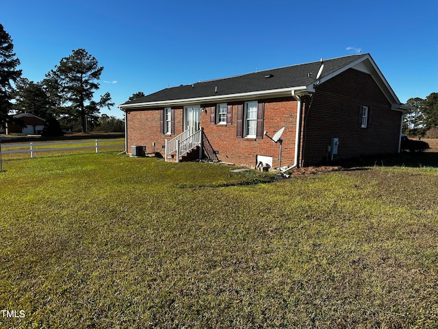 back of house featuring a lawn and central AC unit