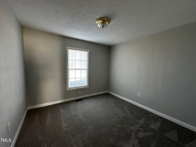 carpeted empty room with a textured ceiling