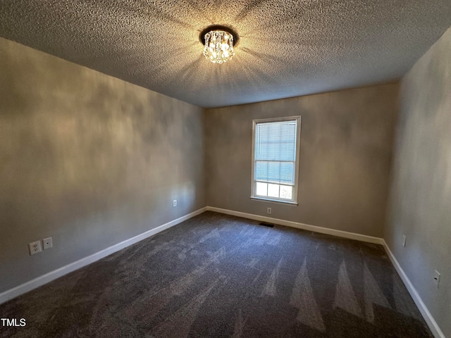 carpeted empty room with a textured ceiling