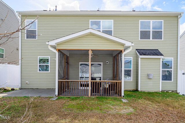 rear view of property featuring a yard and a sunroom