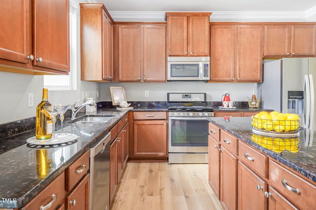 kitchen with stainless steel appliances, light hardwood / wood-style flooring, ornamental molding, and sink