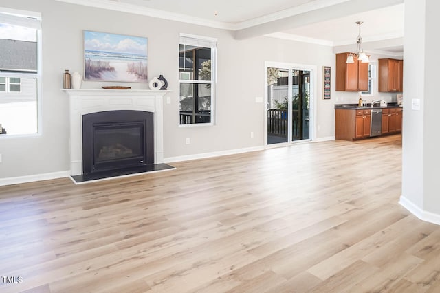 unfurnished living room featuring a notable chandelier, light hardwood / wood-style floors, sink, and crown molding