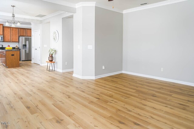 unfurnished living room featuring ceiling fan with notable chandelier, light hardwood / wood-style floors, and crown molding