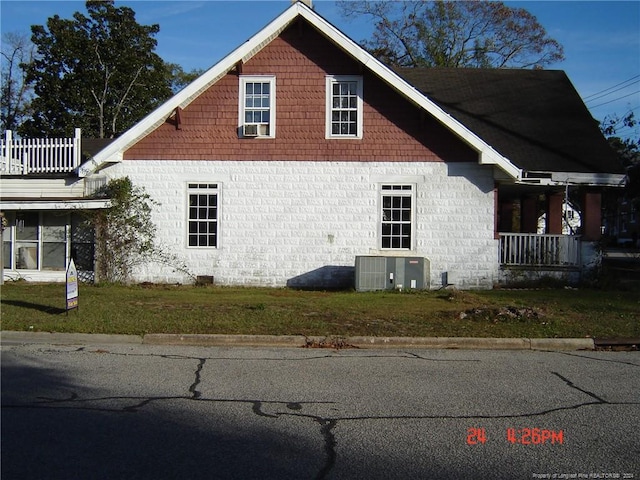 view of home's exterior with a lawn, a balcony, and central AC unit