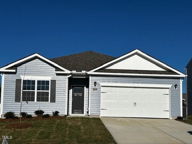 ranch-style house featuring a front yard and a garage