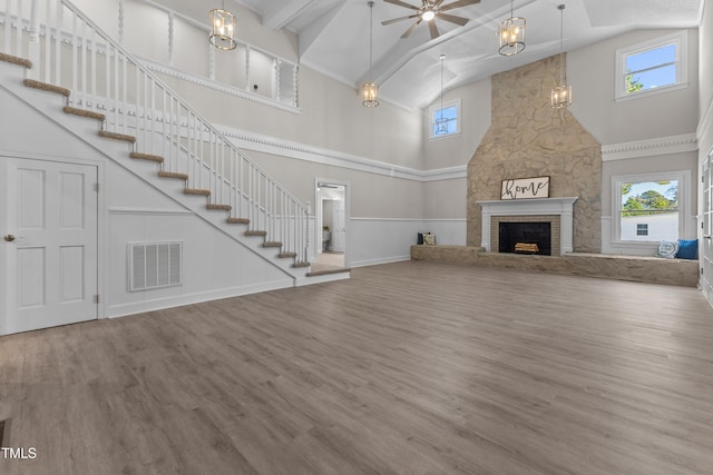 unfurnished living room with wood-type flooring, high vaulted ceiling, a large fireplace, and ceiling fan