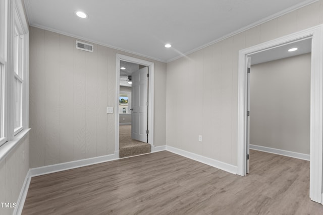 unfurnished bedroom featuring ornamental molding and light wood-type flooring