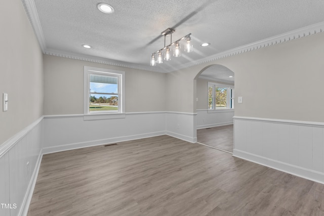 interior space featuring crown molding, hardwood / wood-style flooring, and a textured ceiling