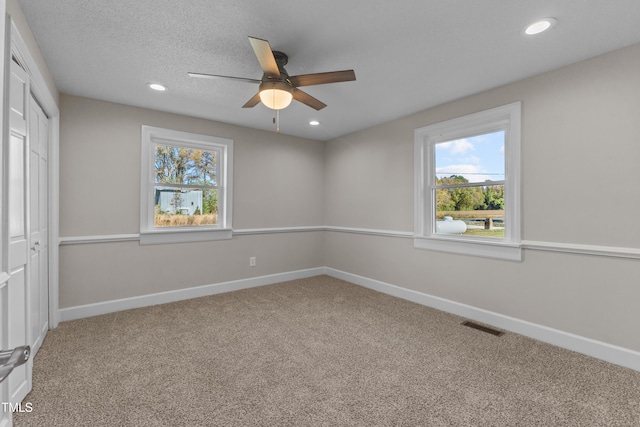 carpeted empty room with a textured ceiling and ceiling fan