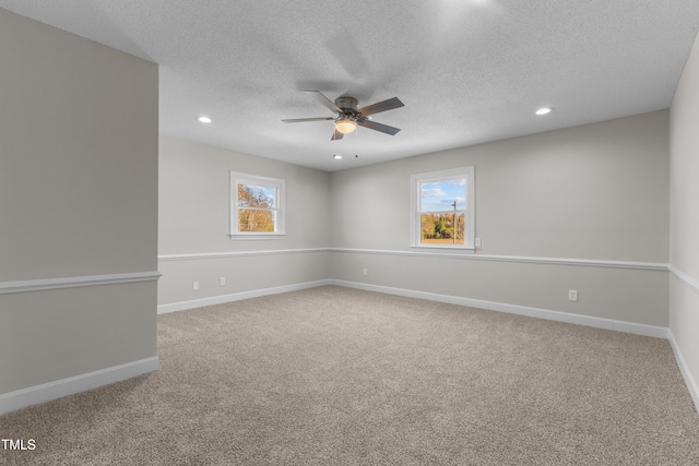 empty room with ceiling fan, a healthy amount of sunlight, and carpet