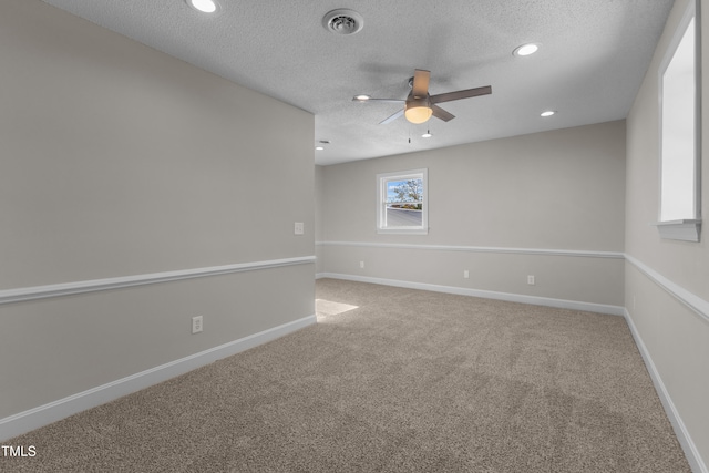 carpeted spare room with ceiling fan and a textured ceiling