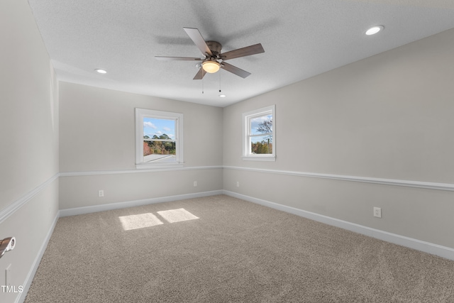 unfurnished room with ceiling fan, carpet flooring, and a textured ceiling