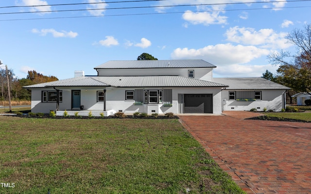 modern inspired farmhouse featuring a garage and a front lawn