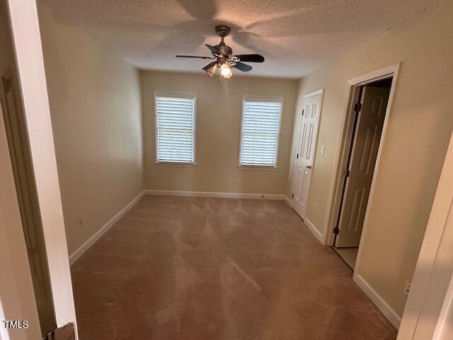 empty room featuring a textured ceiling, carpet floors, and ceiling fan