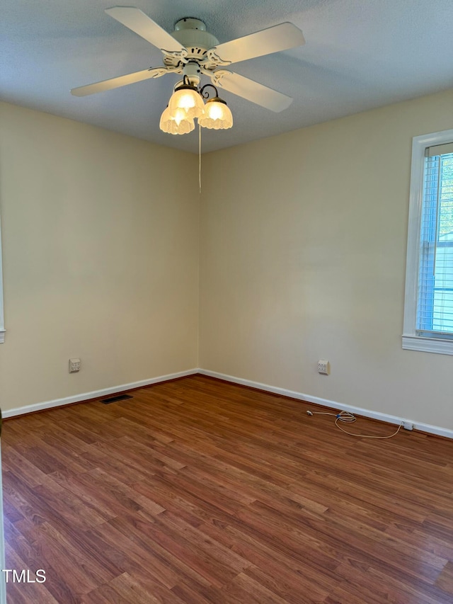 unfurnished room with ceiling fan and dark wood-type flooring