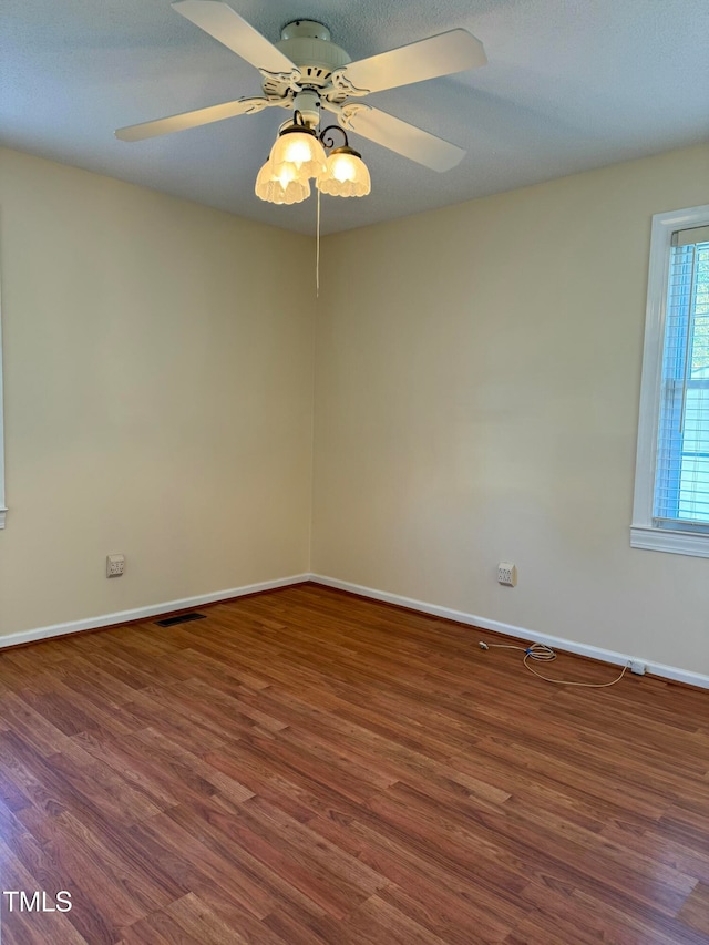 unfurnished room with dark hardwood / wood-style floors and ceiling fan