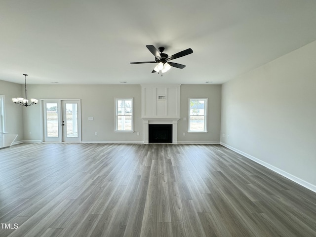 unfurnished living room featuring baseboards, a healthy amount of sunlight, wood finished floors, and a fireplace