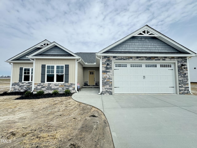 craftsman house with stone siding, a garage, board and batten siding, and driveway