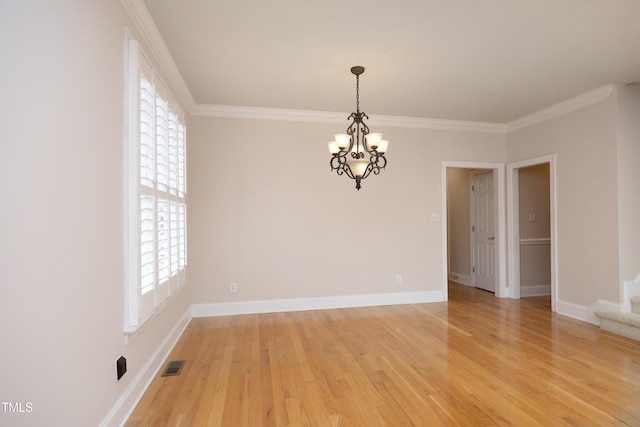 spare room featuring light hardwood / wood-style floors, crown molding, and a notable chandelier