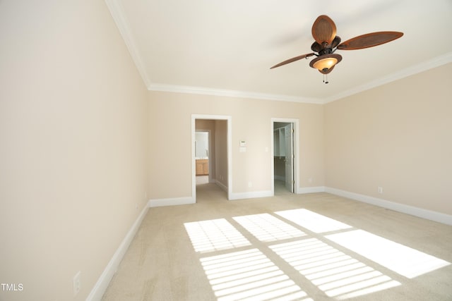 unfurnished bedroom with a spacious closet, ceiling fan, crown molding, light colored carpet, and a closet