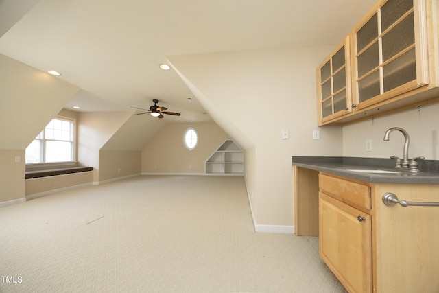 kitchen with ceiling fan, sink, light brown cabinets, light colored carpet, and lofted ceiling