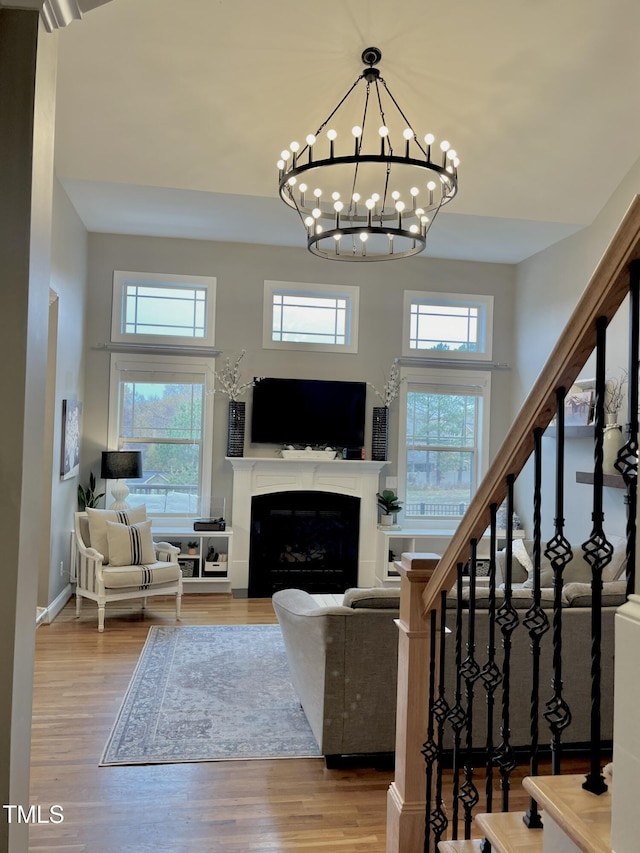 living room featuring a chandelier, wood-type flooring, and a high ceiling