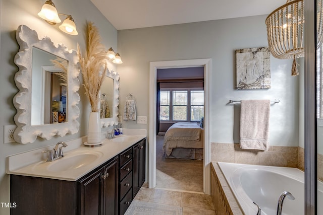 bathroom featuring tiled tub, tile patterned flooring, and vanity