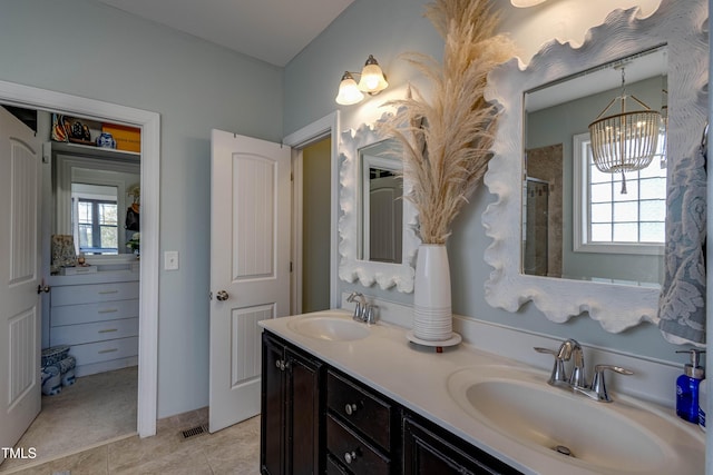 bathroom featuring tile patterned flooring, vanity, a shower, and an inviting chandelier