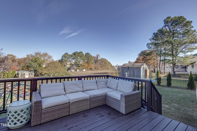 wooden terrace with an outdoor living space, a storage unit, and a yard