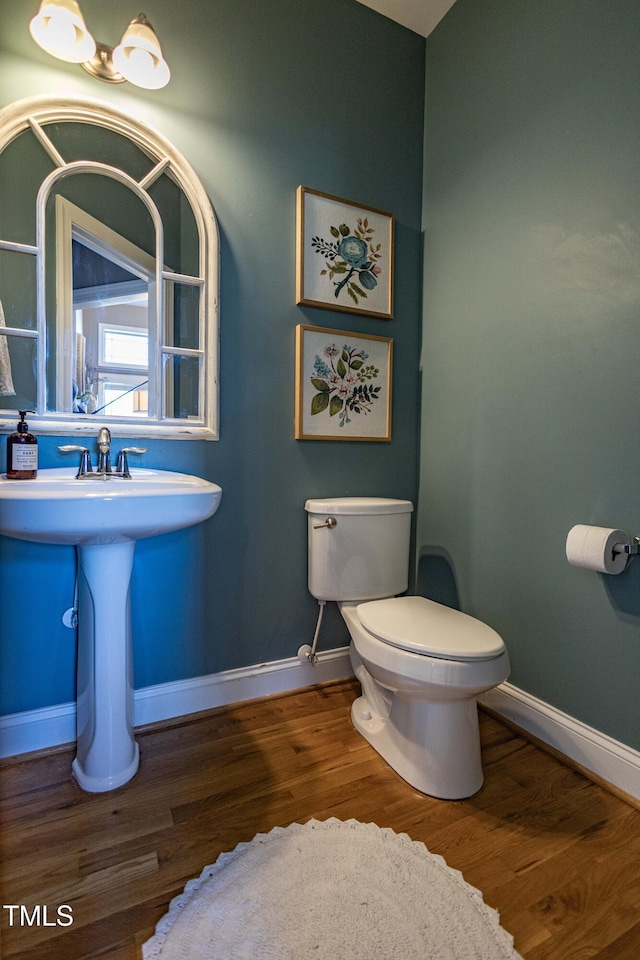 bathroom featuring wood-type flooring and toilet