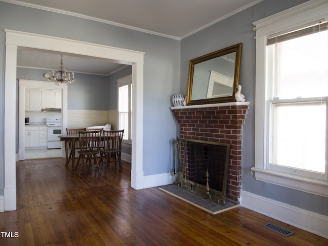 living room with dark hardwood / wood-style flooring, a fireplace, a wealth of natural light, and a chandelier