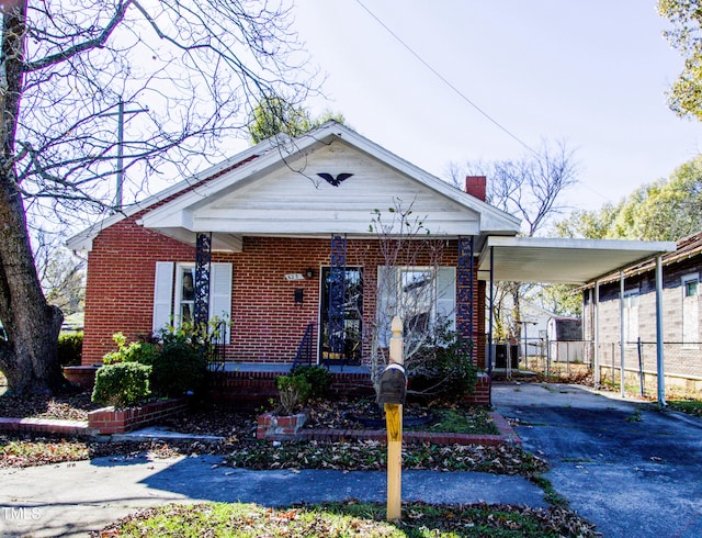 bungalow-style home with covered porch and a carport