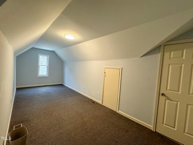 bonus room featuring lofted ceiling and dark carpet