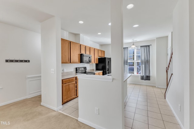 kitchen featuring pendant lighting, light colored carpet, and black appliances