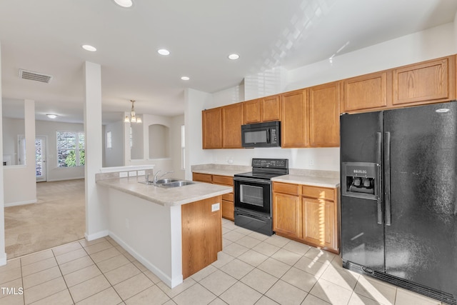 kitchen with an inviting chandelier, black appliances, sink, light tile patterned floors, and kitchen peninsula