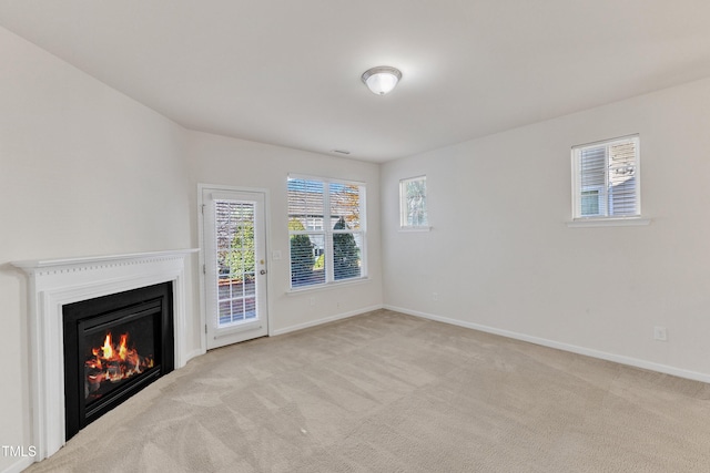 unfurnished living room with light carpet and a wealth of natural light