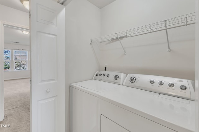 washroom with washer and clothes dryer and light colored carpet