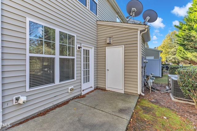 doorway to property with central air condition unit and a patio