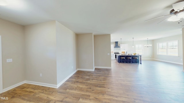 1407 Stoney Creek Church Rd, Goldsboro, NC 27534 - unfurnished living room with a ceiling fan, wood finished floors, baseboards, and a chandelier