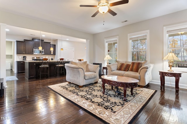 living room with dark hardwood / wood-style floors and ceiling fan